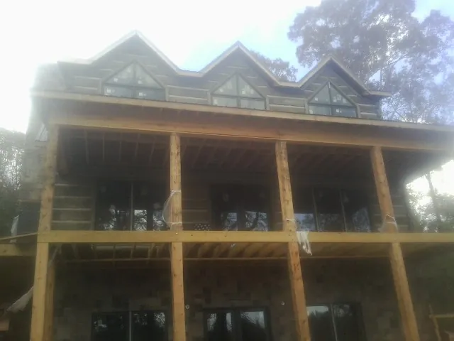 Dormers and porch framing on a large log home under construction — Roof Coating work by our crew in Red Banks