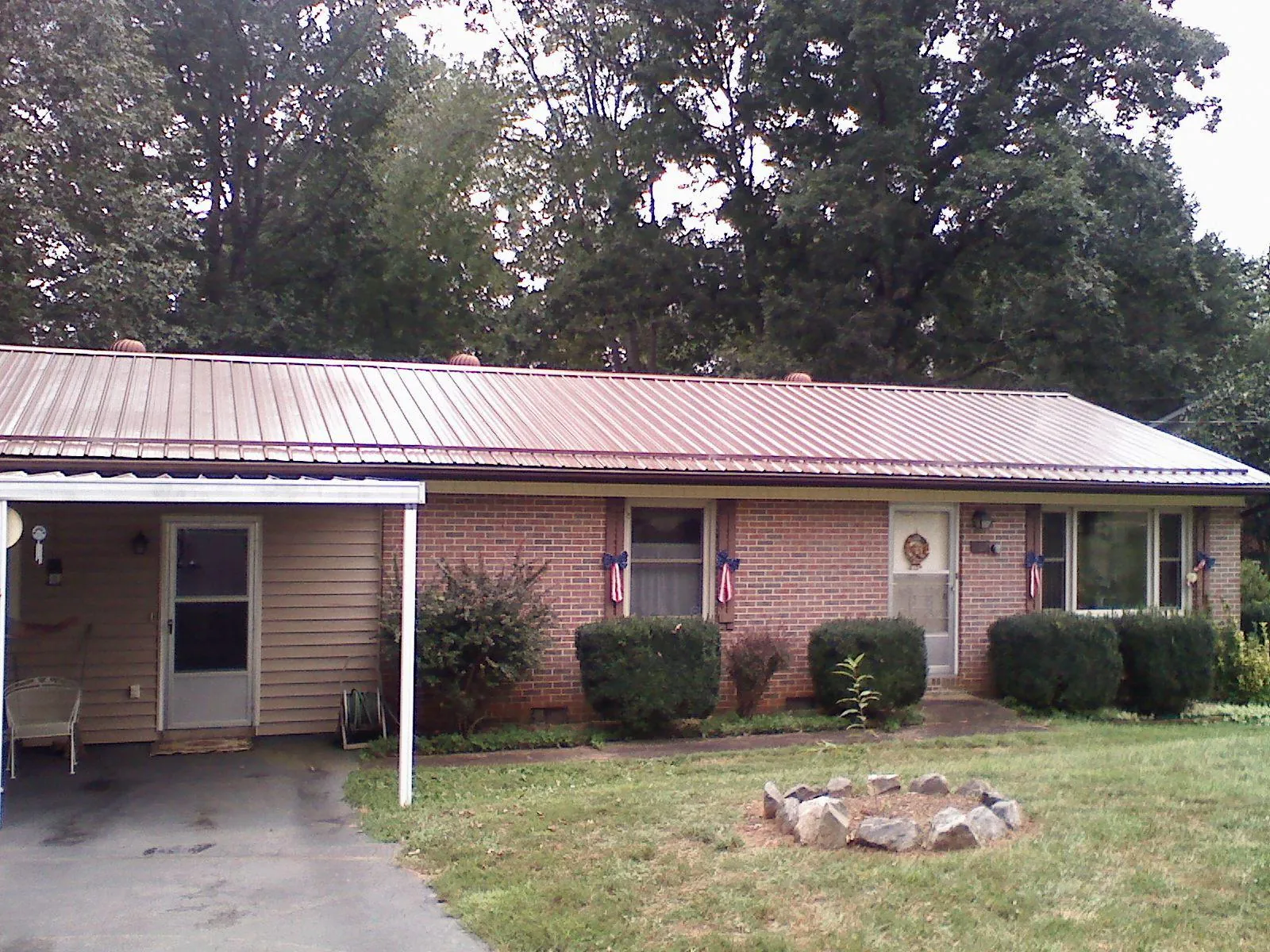 Bronze metal roof and carport on a brick ranch home — Roof Repair work by our crew in Red Banks